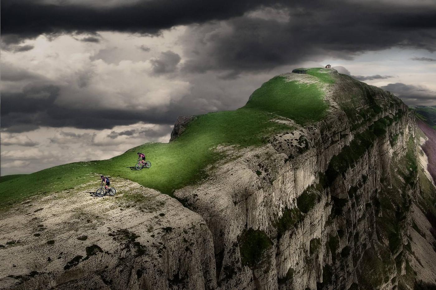 Two cyclists on top of a mountain